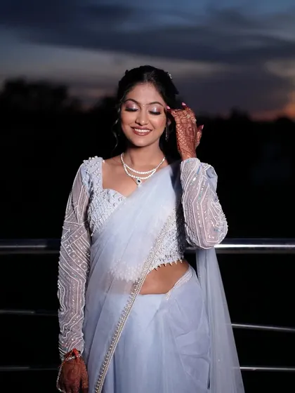 A close-up of the bride's happy expression. The soft, shimmery eyeshadow and perfectly applied lipstick complete her sangeet look.
