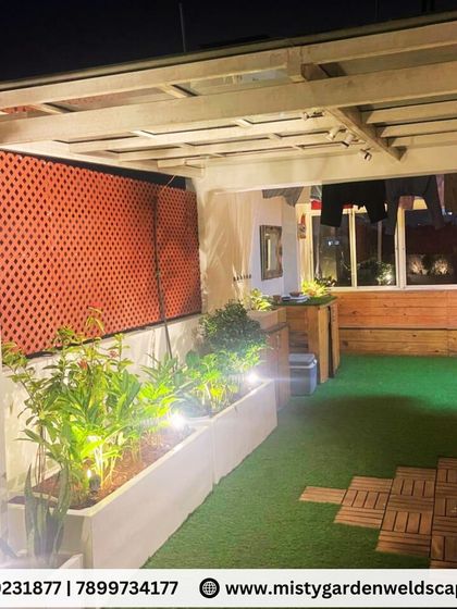 The planters are lit from within, creating a warm glow that highlights the plants and adds to the cozy atmosphere of the terrace at night.