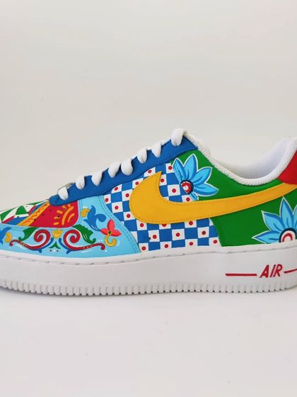 Another angle of the mismatched Indian art sneakers, showing the different swoosh colours. One is a bold yellow and the other a classic blue, tying into the various colours used across the shoe.