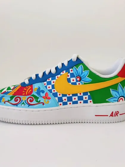 Another angle of the mismatched Indian art sneakers, showing the different swoosh colours. One is a bold yellow and the other a classic blue, tying into the various colours used across the shoe.