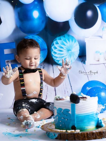 An action shot from a cakesmash session, capturing the moment the baby gets his hands covered in cake for the first time.