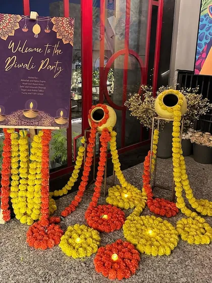 A traditional and welcoming entrance for a Diwali party. We used a custom welcome sign, marigold garlands flowing from matkas (pots), and small diyas for a classic festive look.