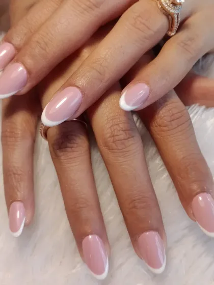 A perfect example of a classic French manicure. This design features a sheer pink base and clean, white tips on beautifully shaped oval nails for a look of pure elegance.