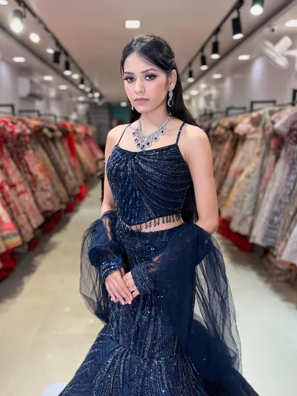 This navy blue fish-cut lehenga is a modern and glamorous choice for a reception or cocktail party. The sequin work and spaghetti-strap top create a chic, contemporary silhouette.