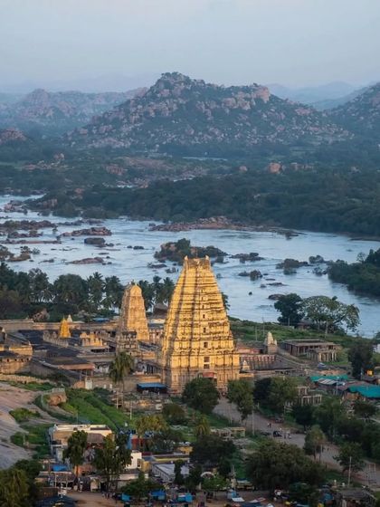 A stunning view of the Virupaksha Temple and the Tungabhadra river from Hemakuta Hill in Hampi.