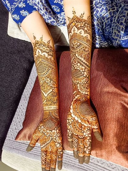 A full view of an intricate bridal design, showing the beautiful patterns on both arms.