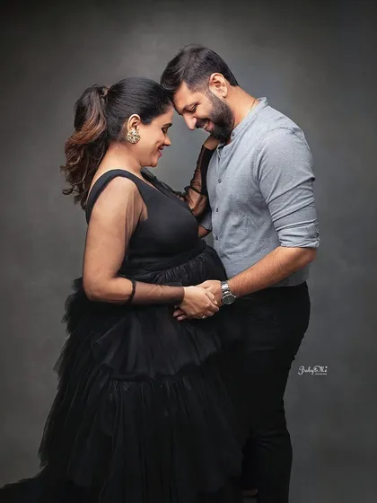 A beautiful, intimate portrait of an expecting couple. The dark, moody backdrop and the elegant black gown create a very sophisticated and timeless feel.