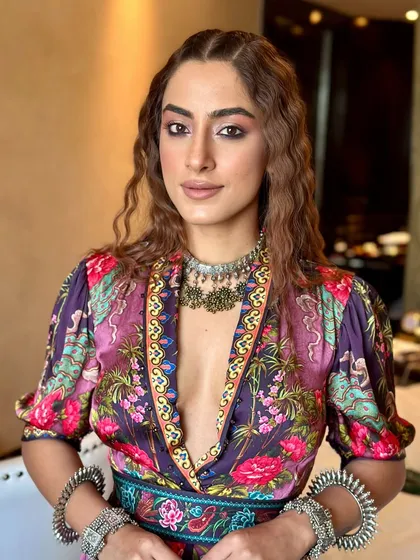A direct, engaging shot from a fashion lookbook. The makeup is centered around a warm, smoked-out eye to create a captivating gaze, paired with luminous skin that looks healthy and radiant on camera.