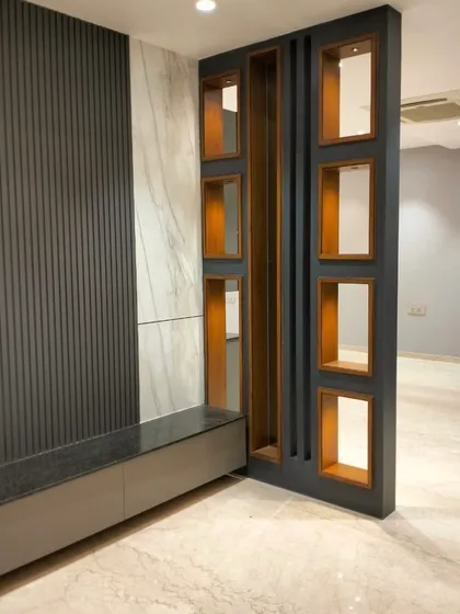 This partition is more than a divider; it's a statement piece. I designed it to create a visual separation while maintaining an open feel, using a mix of fluted panels, marble-finish laminate, and integrated display niches to add both function and style.