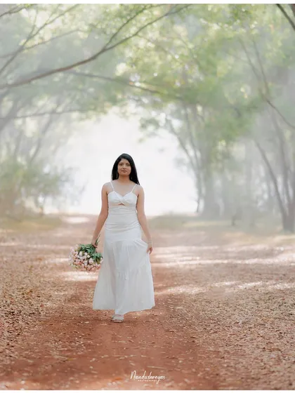 A solo portrait of the bride-to-be walking down a misty, tree-lined path, creating a serene and dreamlike image.