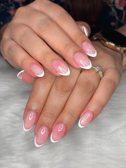 A delicate and dreamy look with classic white French tips and a subtle pink aura blush on the nail bed.