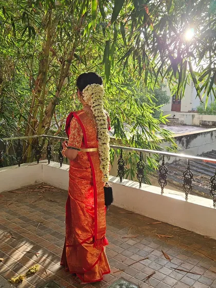 A back view of a traditional bridal hairstyle. The long braid is fully covered with beautiful jasmine flowers (Mallipoo), a timeless look for any South Indian bride.