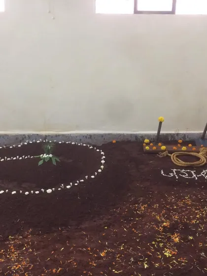 The 'lal mati' pit decorated for the inauguration puja. The tools used to maintain the pit are also blessed, honoring every aspect of our tradition.