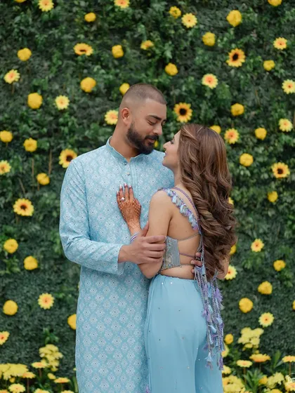 A sweet couple portrait against a wall of yellow flowers during their Haldi event at the Westin Mumbai. The decor perfectly complemented the bright, happy mood of the ceremony.