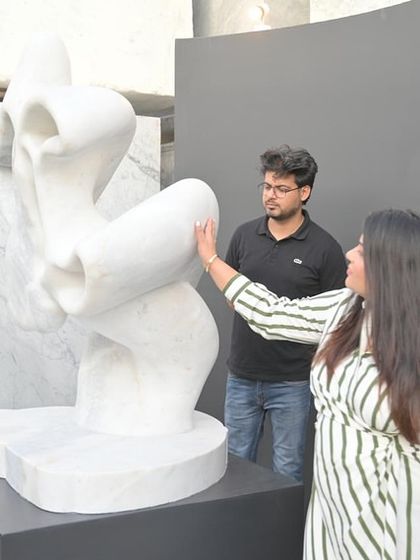 Aishwarya interacting with a modern marble sculpture, feeling its form and texture.