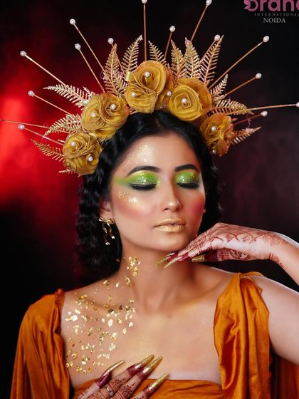 This pose highlights the gold leaf accents on the collarbone and the intricate details of the headpiece.