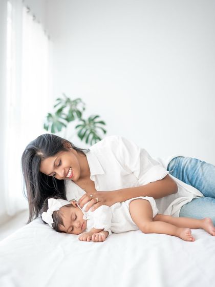 A quiet moment between mother and baby. The simplicity of the white bed and natural light makes this image feel so peaceful.