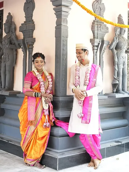 A classic wedding portrait of the couple, showcasing their coordinated traditional outfits.