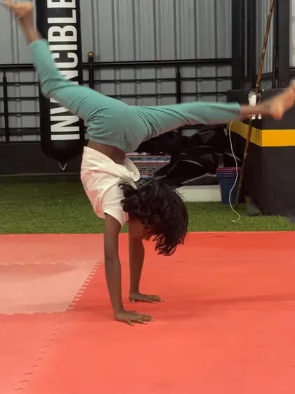 A young boy holds a strong handstand, demonstrating the progress he's made in our kids' gymnastics program.