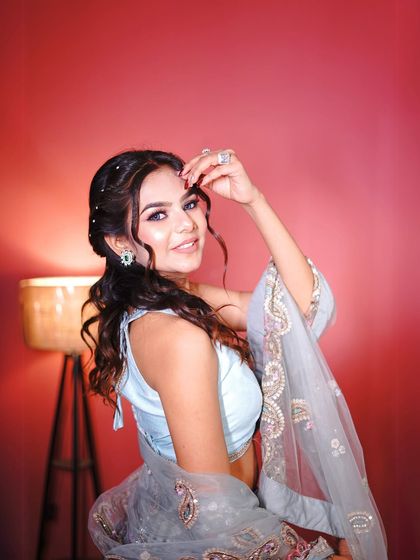 A close-up on the beautiful hair and makeup that complements this floral lehenga. Notice the subtle green eyeshadow that picks up the tones in the outfit.