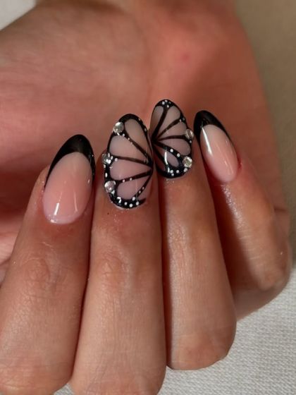 A truly unique design featuring black French tips that come together to form butterfly wings, accented with tiny rhinestones.