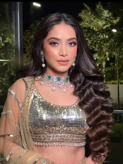 This angle highlights the length and volume of the curls, achieved with a combination of technique and extensions.