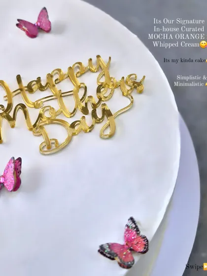 A Mother's Day cake with a simple, elegant design featuring a "Happy Mother's Day" topper and delicate pink butterflies.