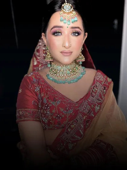 A bride in a red and gold lehenga, looking absolutely radiant.