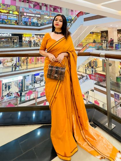 A full-length shot at the mall, proving that a well-styled saree is perfect for any setting. The structured bag adds a modern, chic element to the traditional drape.
