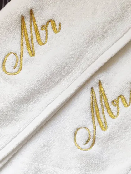 It's all in the details! This is a close-up of my classic 'Mr & Mrs' embroidery in a stunning gold thread on premium white towels. This elegant cursive font is my most requested style for wedding and anniversary gifts.