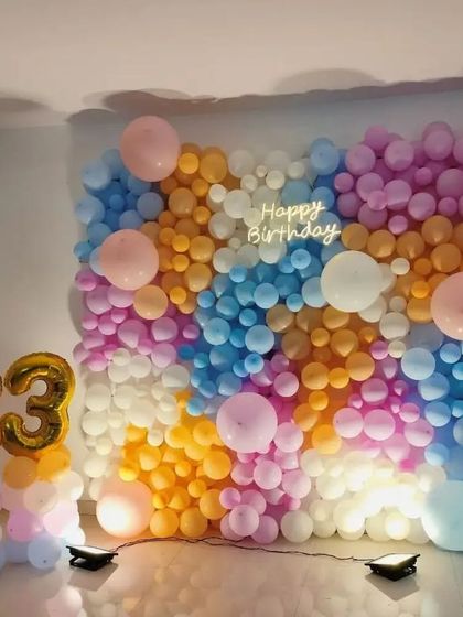 A colorful balloon wall for an 83rd birthday. This unique backdrop uses a mix of pastel and bright balloons to create a joyful and celebratory atmosphere.