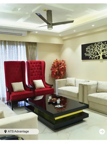 A bold and dramatic living room featuring high-back red chairs and a sleek black coffee table. The design makes a strong statement with its contrasting colors and luxurious feel.