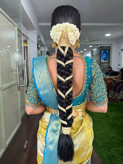 A classic fishtail braid woven with a gold ribbon, finished with a traditional jasmine gajra. This hairstyle is both elegant and secure for a long day of festivities.
