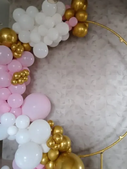 A beautiful and simple balloon ring in progress. This arch of pink, white, and chrome gold balloons on a gold frame is a versatile piece for baby showers, birthdays, or bridal showers.