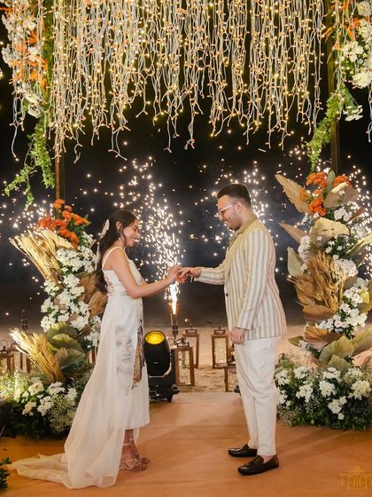 A magical moment of commitment under a canopy of fairy lights, punctuated by dazzling fireworks. This setup was designed for a dramatic and romantic ring exchange, creating an unforgettable memory for the couple and their guests.