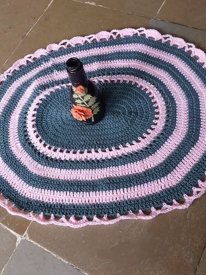 The oval table mat used as a decorative base for a vase.