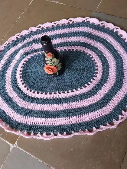 The oval table mat used as a decorative base for a vase.