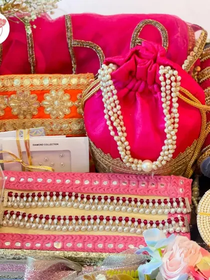 A close-up of our bridal essentials hamper, showing the intricate details of the pearl-studded potli and gota patti work on the pouches.
