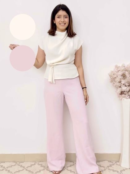 A soft and feminine color palette. This outfit combines a cream-colored top with light pink trousers for a delicate and sophisticated monochromatic look.