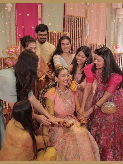 A heartwarming moment as the bride is surrounded by her loved ones during the Haldi ceremony. The decor provides a beautiful, warm backdrop for these precious memories.