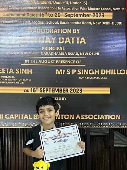 A young champion in the making. Advit Mishra proudly displays his certificate from the Delhi Capital Badminton Association, marking a significant milestone in his budding career.