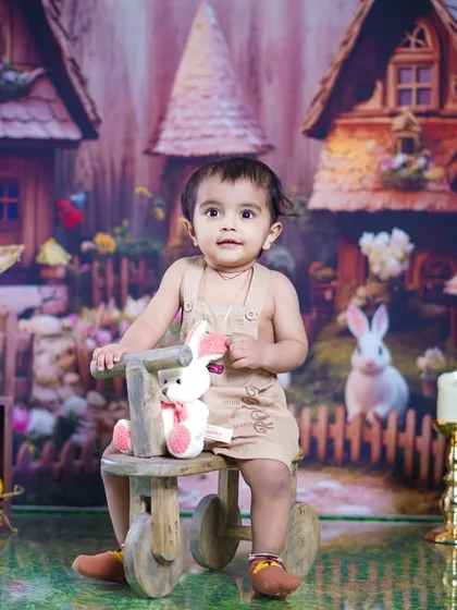 A straight-on portrait of the little girl, looking curious and cute in her bunny-themed outfit.