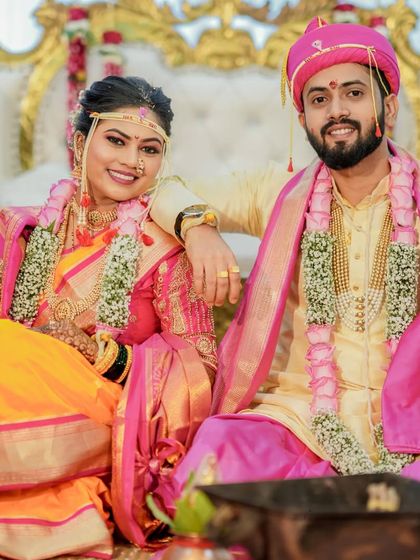 The newlyweds relaxing on their wedding stage. This candid shot captures their personalities and the joy of the moment, surrounded by grand decor.