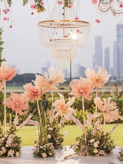 A close-up of the oversized, handcrafted paper flowers that adorned the reception stage. These delicate, pastel-pink creations add a whimsical and artistic touch against the backdrop of the city.