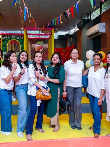 A group of moms posing for a photo, enjoying the party atmosphere at our Playhouse.