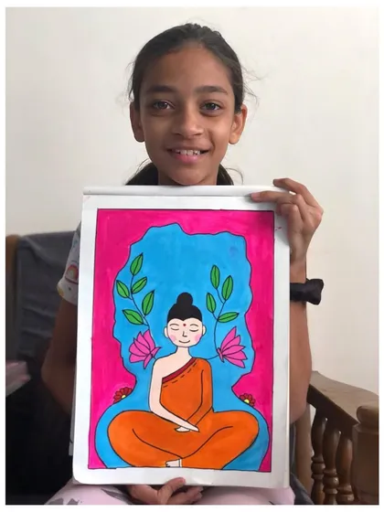 The talented young artist proudly holding her colourful Buddha painting. It's wonderful to see students explore spiritual themes with such creativity.