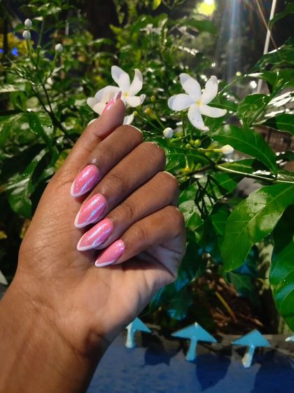 This pink chrome set with sharp, white line details has a cool, futuristic feel. The almond shape of the nails makes the design look even more striking, especially against a natural background.