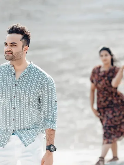 A candid shot with a shallow depth of field, focusing on him while she is blurred in the background. This technique adds an artistic, storytelling quality.