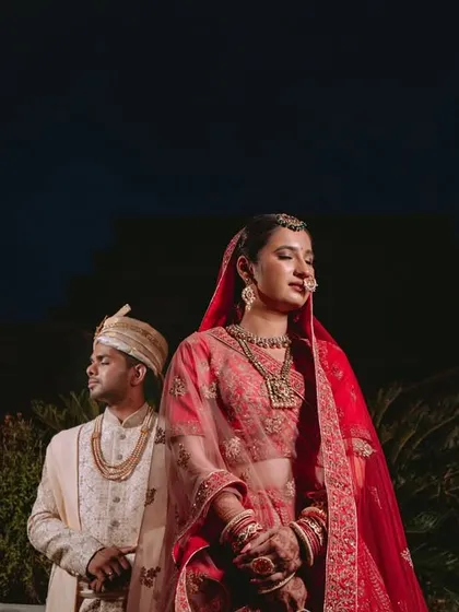 A powerful and regal portrait of the couple standing back-to-back against the dark night sky.