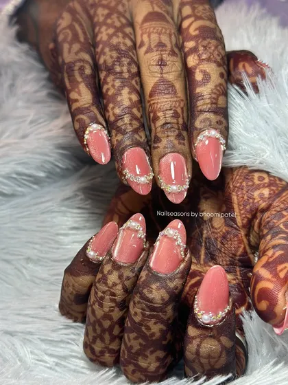 The almond shape of these nails elongates the fingers, and the pearl accents add a touch of classic bridal elegance.